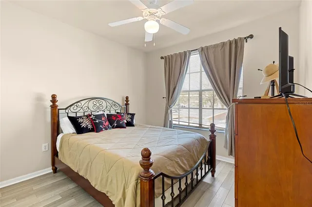 a bedroom with a bed a chandelier and a window