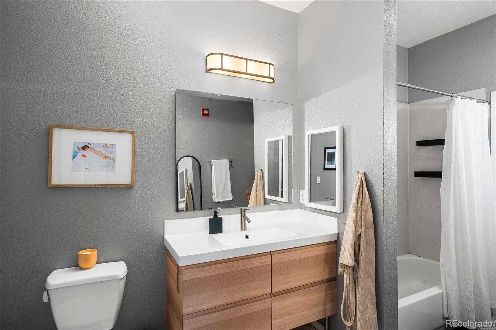 3225 Blake Street, Unit 4 Denver, CO 80205 - Photo 13 of 23 a bathroom with a toilet sink and mirror
