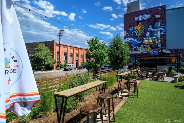 a front view of a residential apartment building with a yard and outdoor seating
