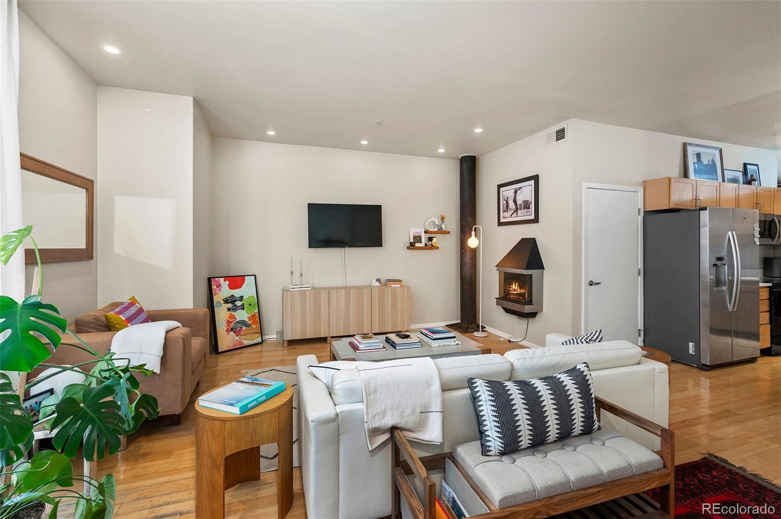 3225 Blake Street, Unit 4 Denver, CO 80205 - Photo 3 of 23 a living room with furniture a flat screen tv and a table