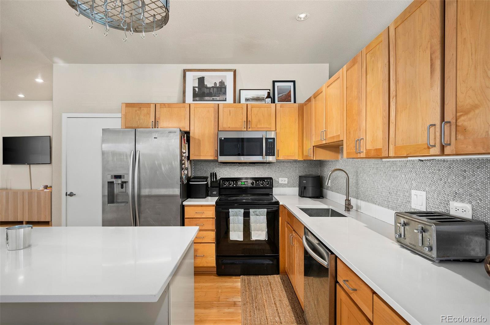 3225 Blake Street, Unit 4 Denver, CO 80205 - Photo 8 of 23 a kitchen with stainless steel appliances a refrigerator sink and wooden cabinets