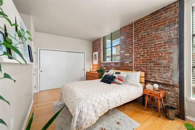 a bedroom with a large bed and a potted plant