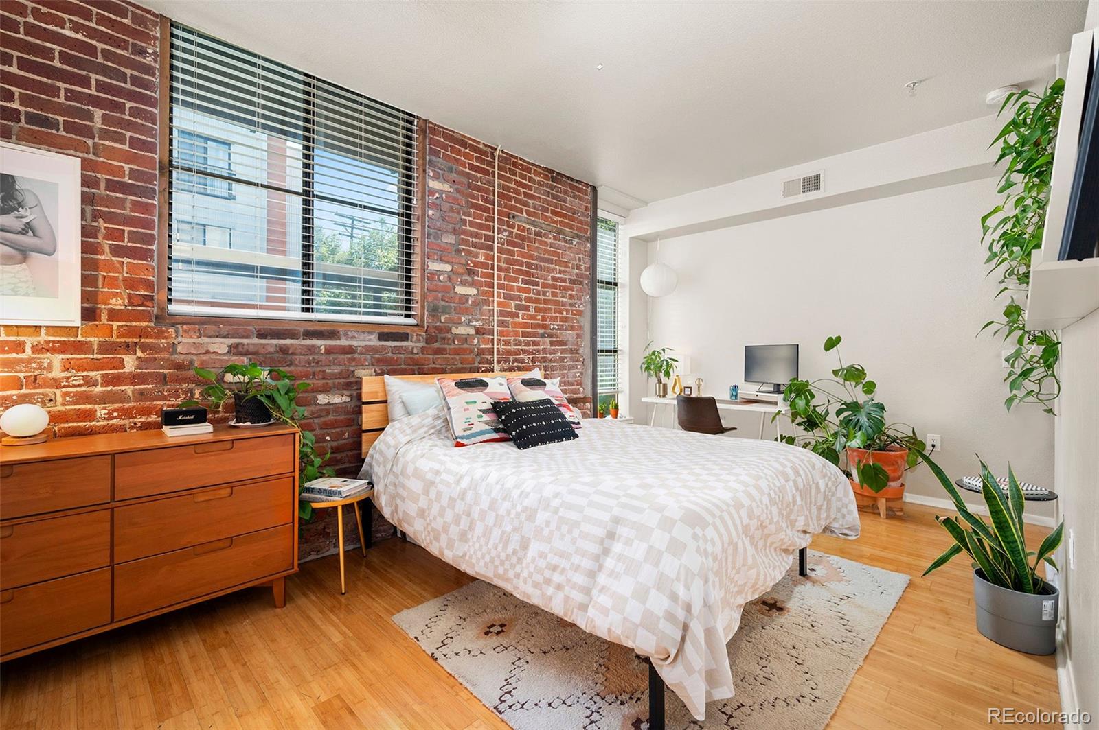 3225 Blake Street, Unit 4 Denver, CO 80205 - Photo 10 of 23 a bedroom with a large bed and a potted plant