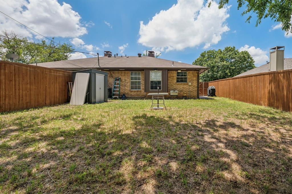 9780 Windy Ridge Road Frisco, TX 75033 - Photo 20 of 25 Expansive backyard featuring a brick exterior, privacy fencing, and a storage shed