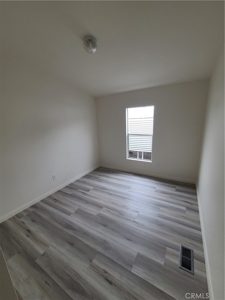 840 East Foothill Boulevard, Unit 64 Azusa, CA 91702 - Photo 17 of 25 wooden floor and window in an empty room