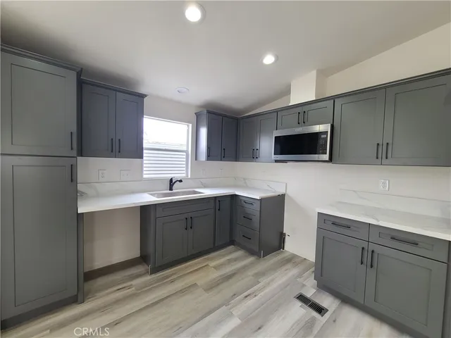 a large kitchen with stainless steel appliances a large counter top and a stove