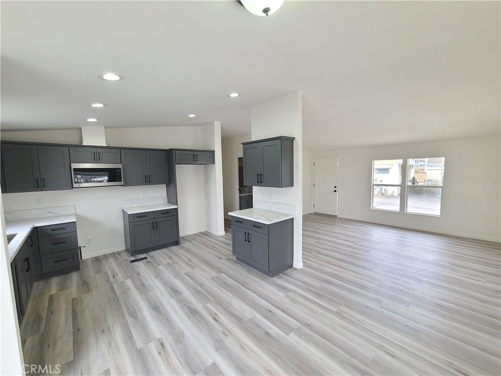840 East Foothill Boulevard, Unit 64 Azusa, CA 91702 - Photo 7 of 25 a large kitchen with stainless steel appliances a large counter top and a stove