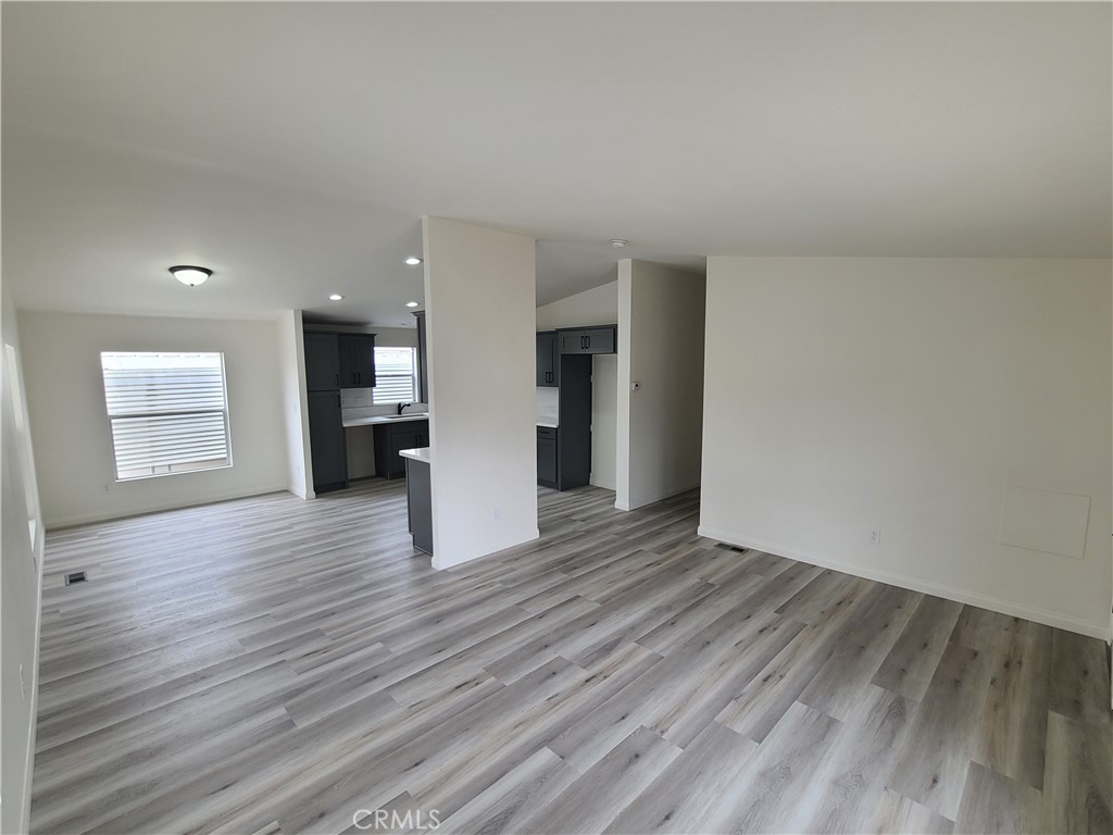 840 East Foothill Boulevard, Unit 64 Azusa, CA 91702 - Photo 8 of 25 a view of empty room with wooden floor and kitchen