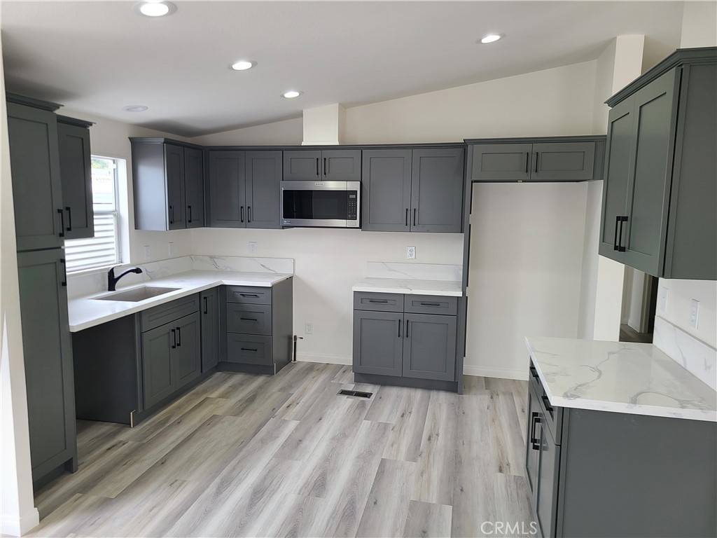 840 East Foothill Boulevard, Unit 64 Azusa, CA 91702 - Photo 10 of 25 a large kitchen with a large counter top a sink stainless steel appliances and cabinets