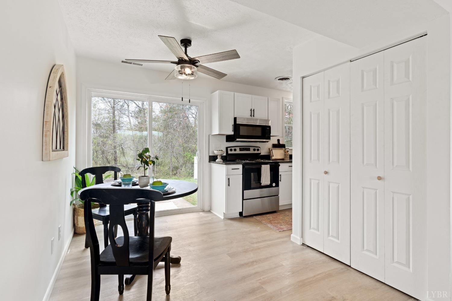 178 Dulwich Drive, Unit 182 Amherst, VA 24521 - Photo 7 of 23 a kitchen with stainless steel appliances kitchen island a table chairs and a refrigerator