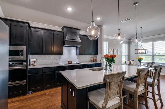 a kitchen with a table chairs and stainless steel appliances