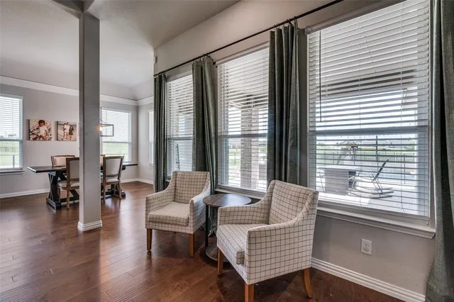 a living room with furniture and two large windows