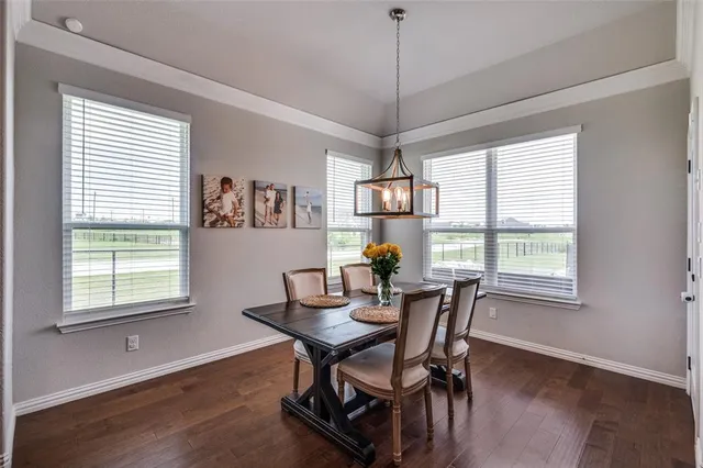 a view of a dining room and livingroom with furniture wooden floor a chandelier