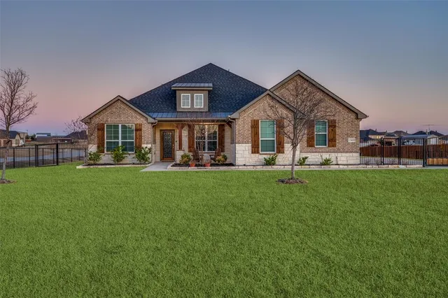 a front view of a house with a garden and trees