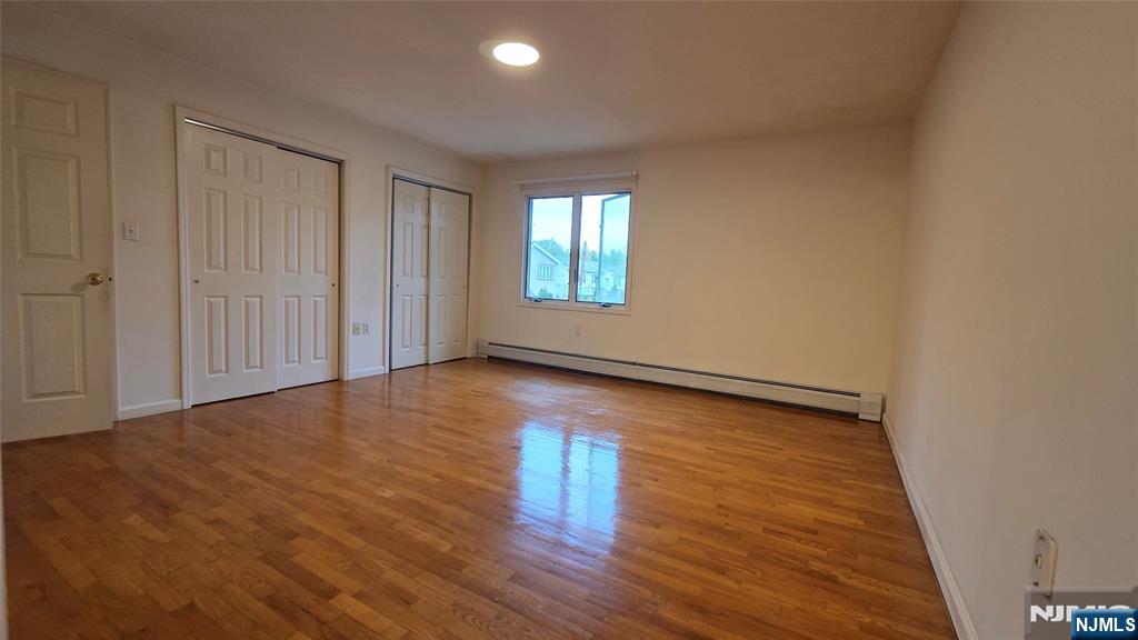 755 Edgewater Avenue, Unit 2 Ridgefield, NJ 07657 - Photo 8 of 13 a view of an empty room with wooden floor and a window