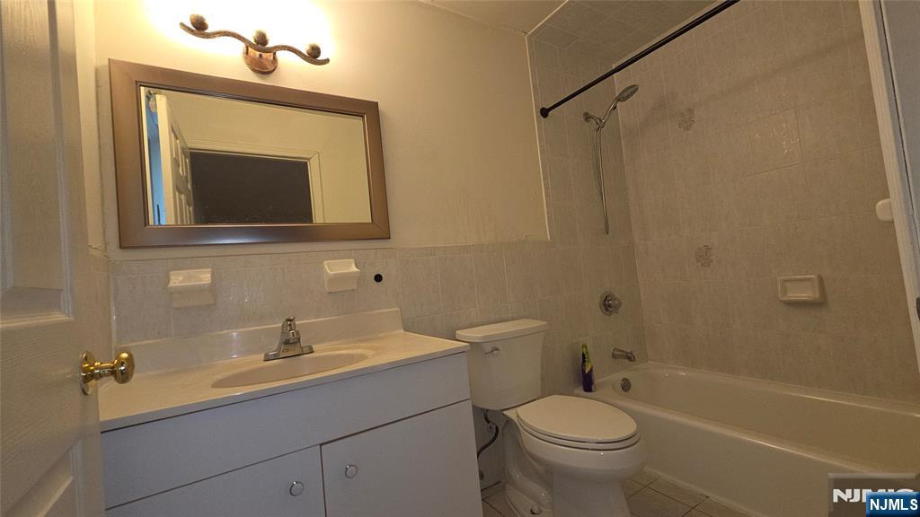755 Edgewater Avenue, Unit 2 Ridgefield, NJ 07657 - Photo 9 of 13 a bathroom with a toilet sink vanity tub and mirror