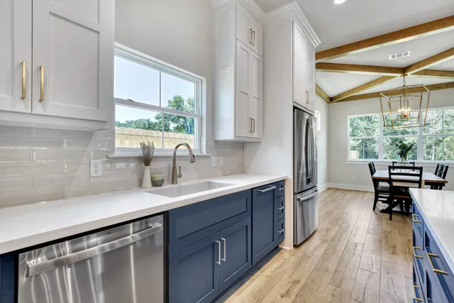a kitchen with a sink a window and chairs
