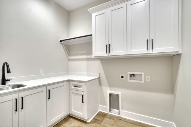 a kitchen with white cabinets and sink
