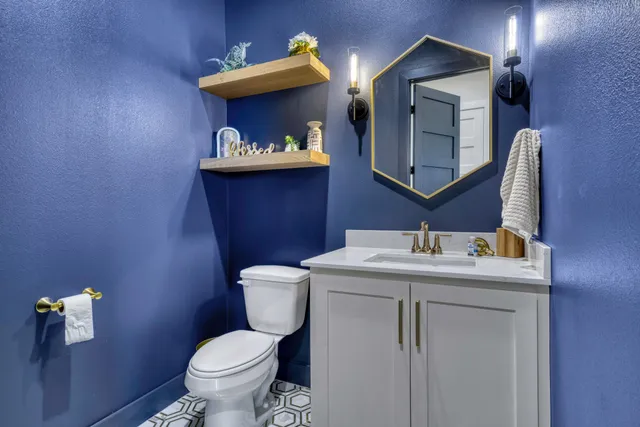 a bathroom with a toilet sink vanity and mirror