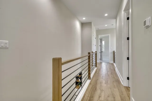 a view of a hallway with wooden floor and staircase