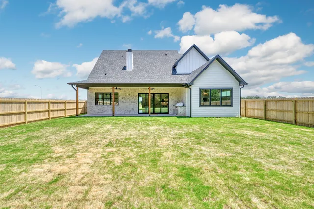 a view of a house with big yard and a garage