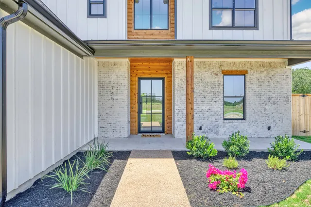 a view of a brick house with flower plants