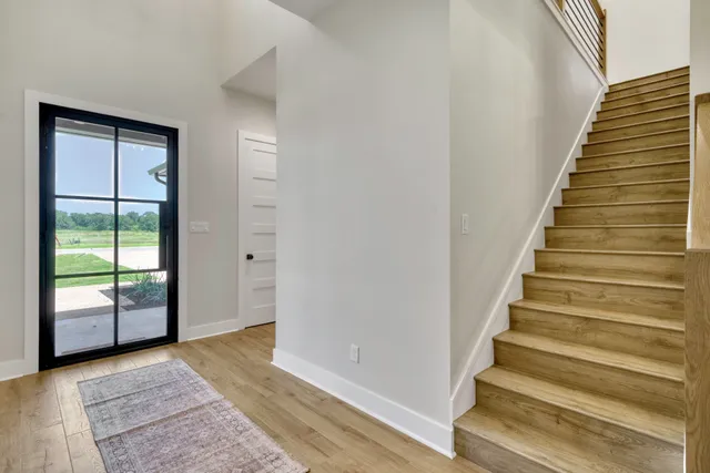 a view of an entryway with wooden floor and stairs