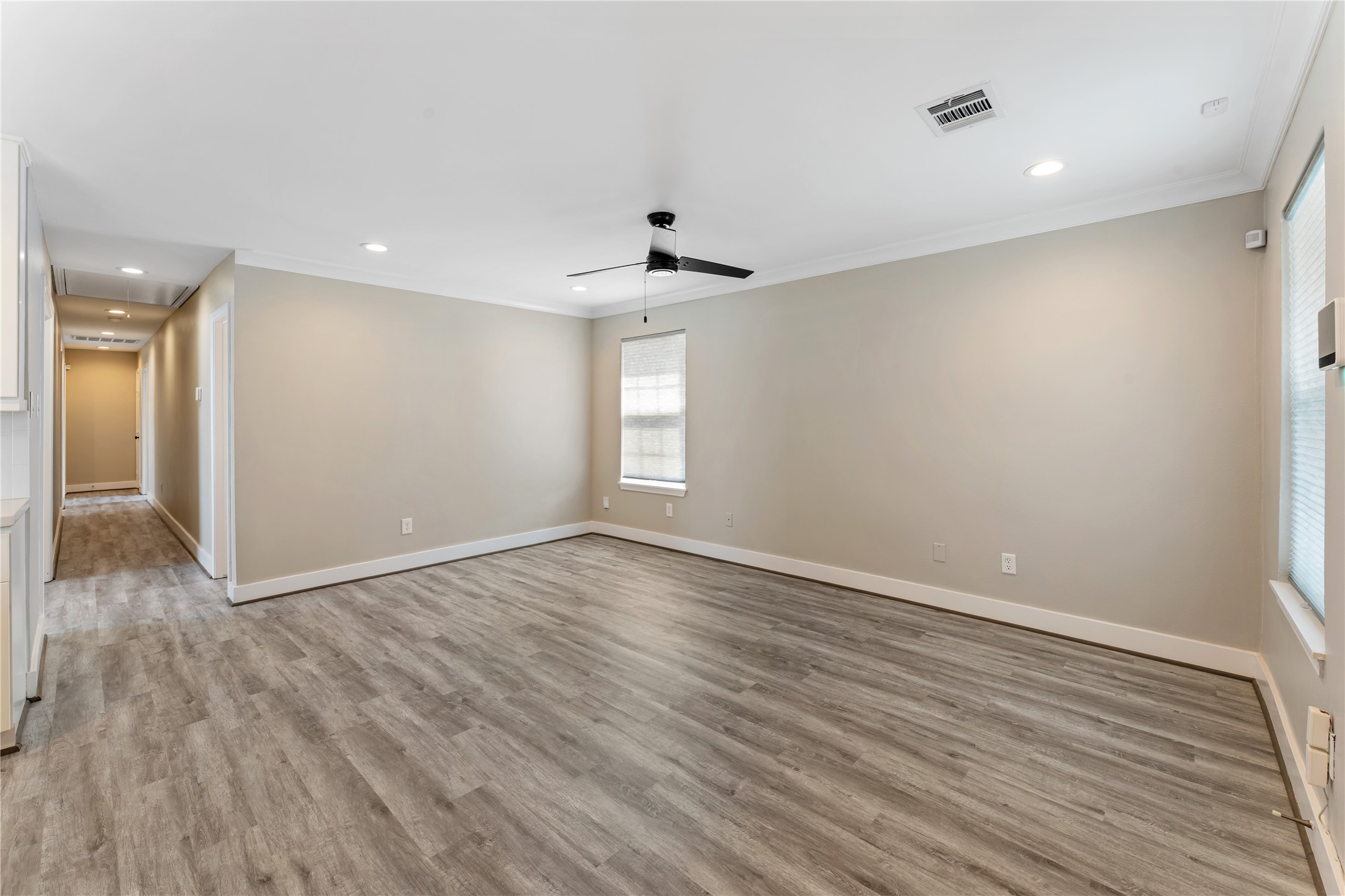 809 East 40th Street Houston, TX 77022 - Photo 7 of 33 Open-concept living connects the updated kitchen with updated ceiling fan and neutral paint.