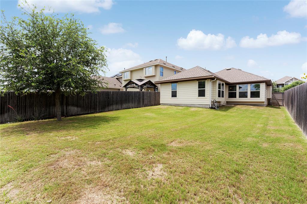 4719 Portillo Way Pflugerville, TX 78660 - Photo 26 of 27 A spacious grassy lawn is fully enclosed by privacy fencing behind this classic residence.