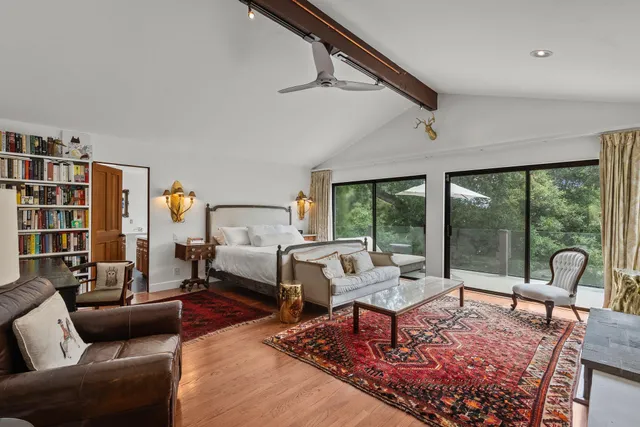 a living room with furniture a flat screen tv and a large window