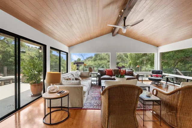 a living room with patio furniture and a floor to ceiling window
