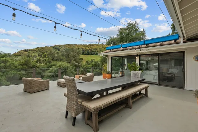 a living room with furniture kitchen view and a large window