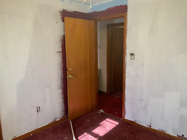 a view of an empty room with a chandelier fan and closet