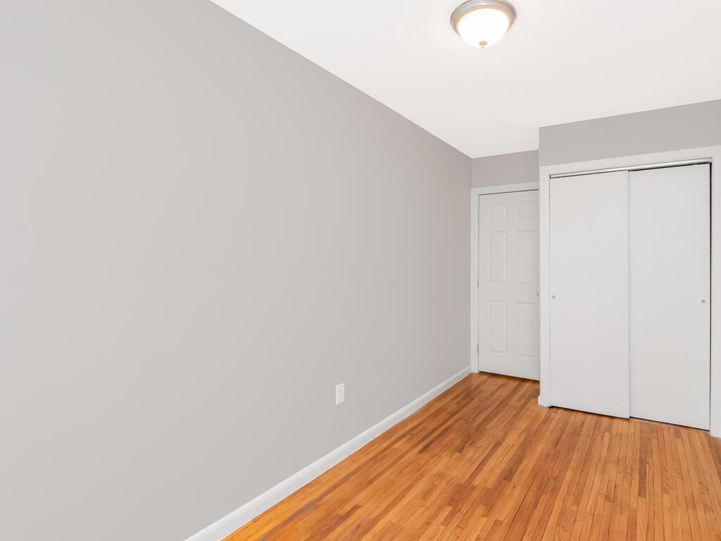 6535 Broadway, Unit 4B Bronx, NY 10471 - Photo 11 of 11 Unfurnished bedroom featuring a closet, light wood-type flooring, and baseboards