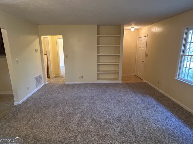 an empty room with windows and closet