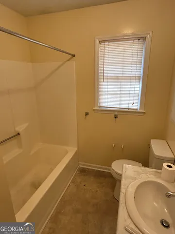 a bathroom with a sink and bathtub with toilet