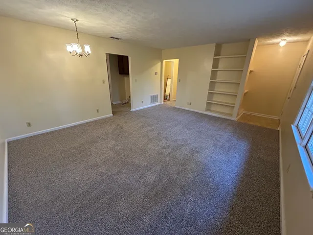 a view of a room with an empty space and a window