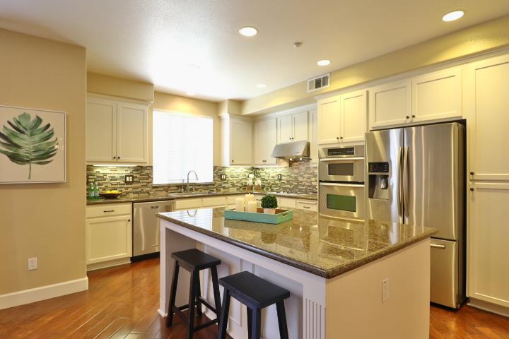 6372 Byron Lane San Ramon, CA 94582 - Photo 23 of 53 a kitchen with stainless steel appliances granite countertop a table chairs sink and refrigerator