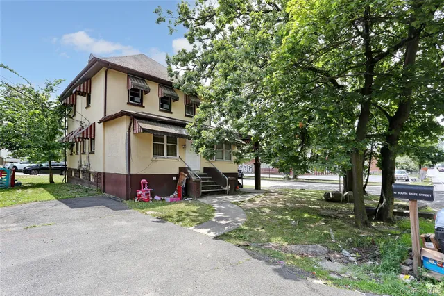 a front view of a house with a yard and trees