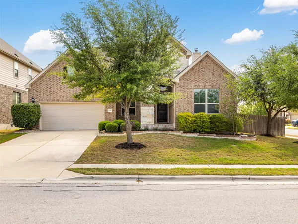 a view of a house with a patio and a yard