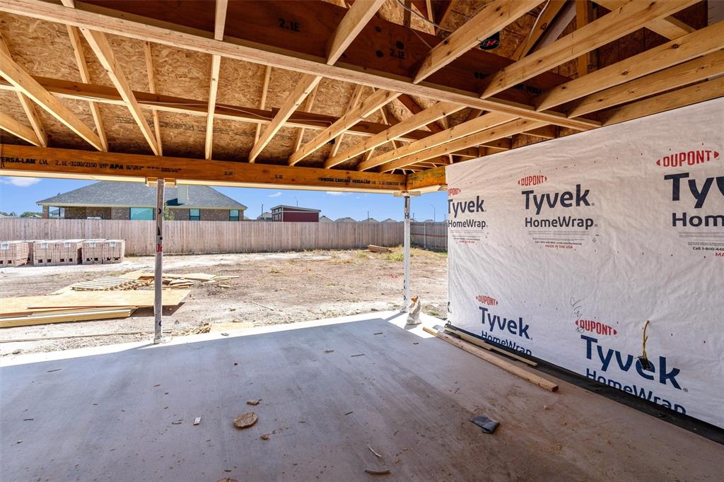 1300 Promised Land Road Hewitt, TX 76643 - Photo 19 of 21 Concrete patio slab with exposed wood beam ceiling, raw wood framing, and Tyvek HomeWrap exterior sheathing