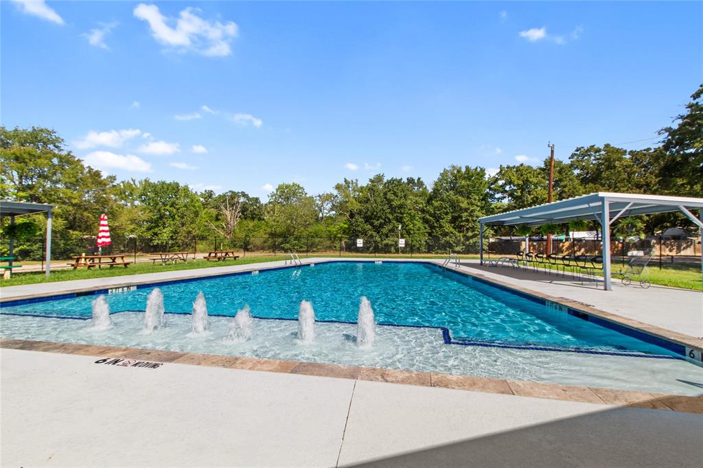 7520 Double Bridge Road Mabank, TX 75156 - Photo 25 of 32 Resort-style swimming pool featuring crystal-clear water, multiple water fountains, concrete decking, and overhead shade structures