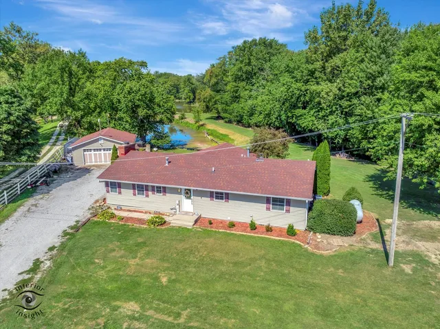 a aerial view of a house with yard and green space