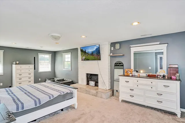 a spacious bedroom with a bed and a dresser