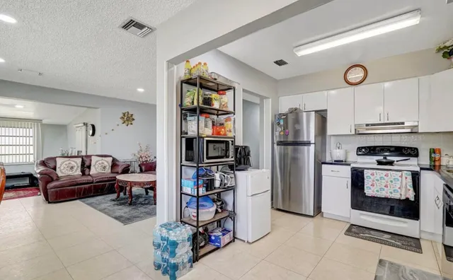a kitchen with stainless steel appliances granite countertop a refrigerator and a stove top oven