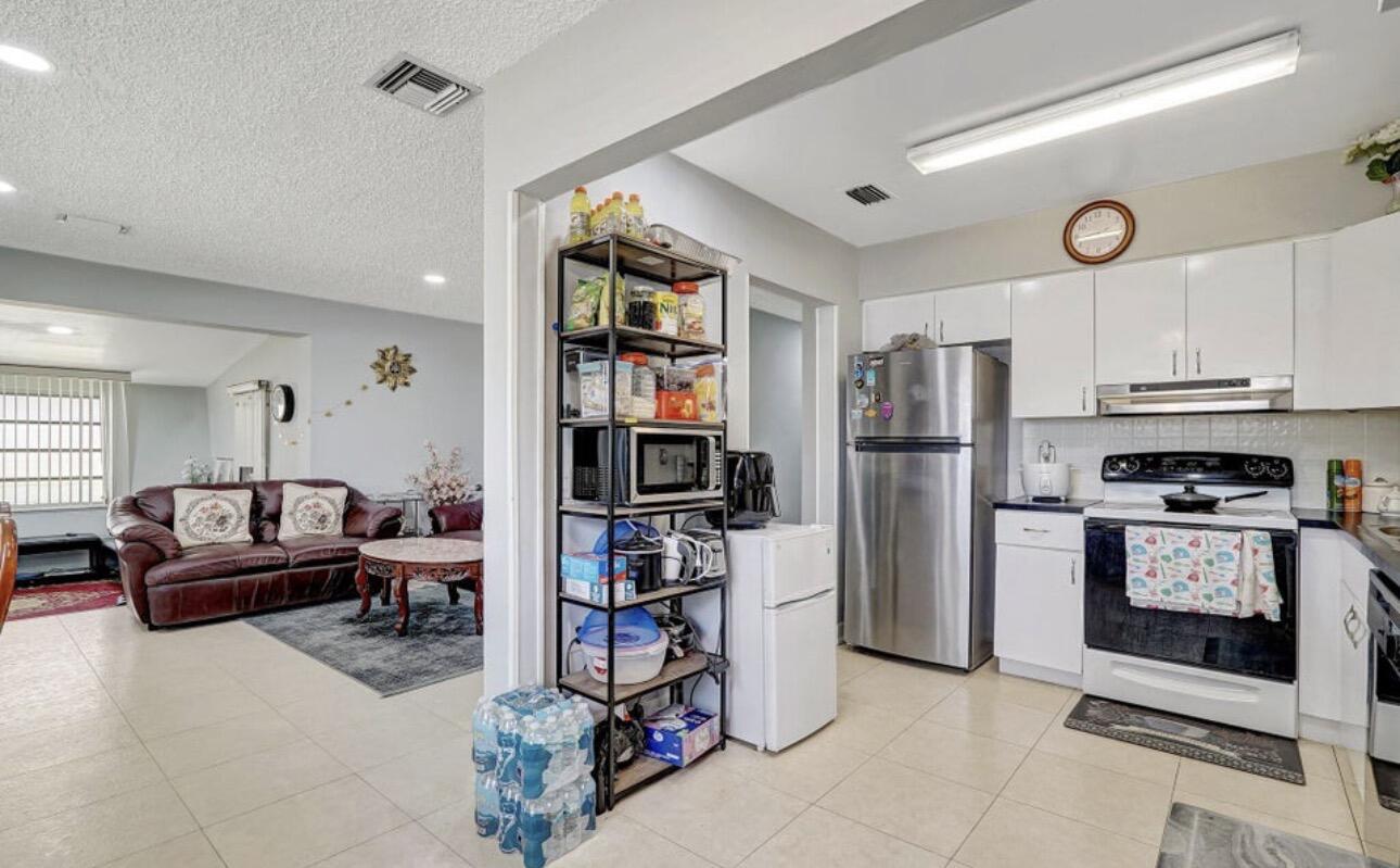 7530 Atlanta Street Hollywood, FL 33024 - Photo 16 of 23 a kitchen with stainless steel appliances granite countertop a refrigerator and a stove top oven