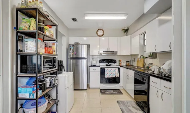 a kitchen with stainless steel appliances granite countertop a refrigerator and a stove top oven