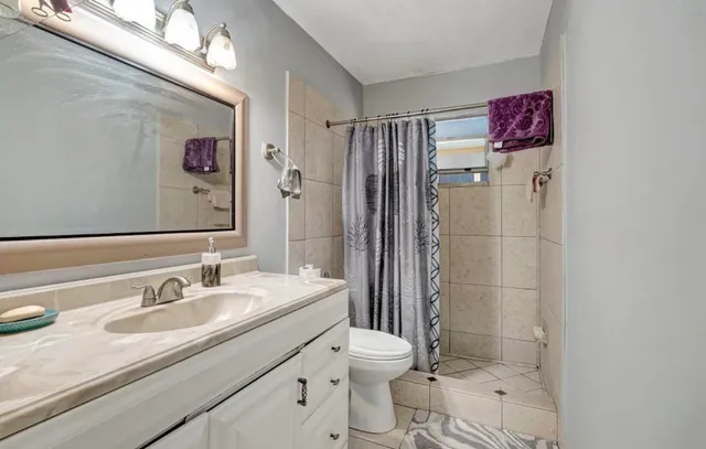 a bathroom with a sink toilet and shower