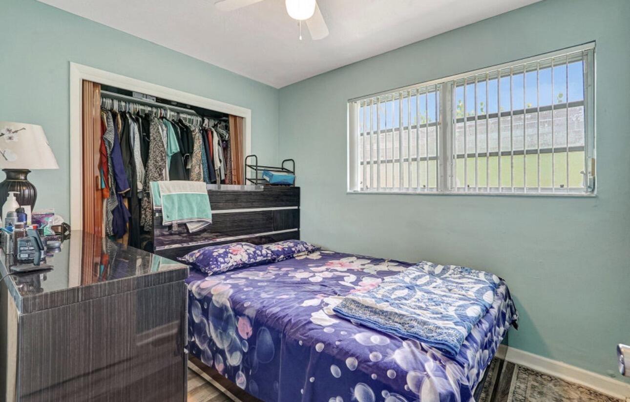 7530 Atlanta Street Hollywood, FL 33024 - Photo 19 of 23 a bedroom with a bed and wooden floor