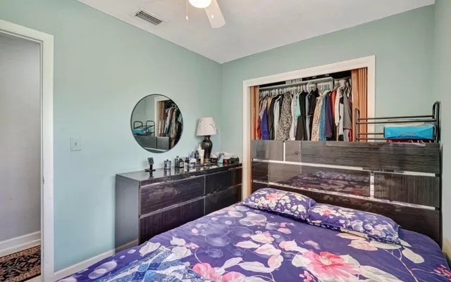 a bedroom with a bed cabinets and painting on the wall